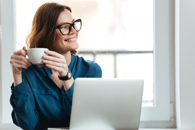 Happy smiling woman holding cup of coffee