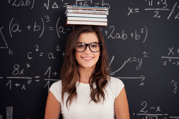 Happy student with books on her head