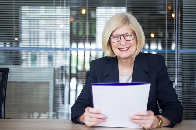 Happy successful business lady doing paperwork