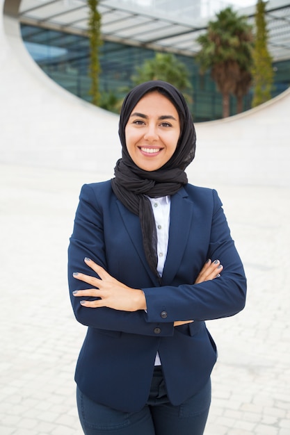 Happy successful Muslim businesswoman posing outside