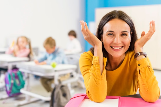 Happy teacher sitting at her desk