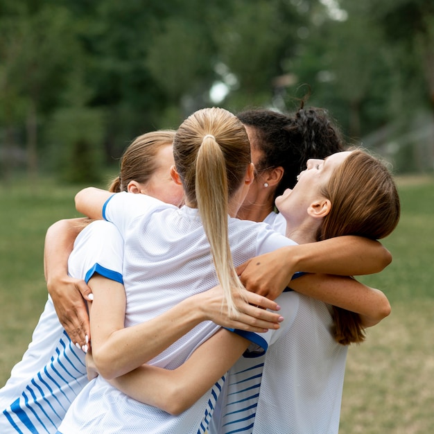 Free photo happy team hugging outdoors