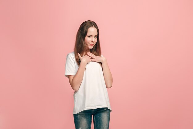 Happy teen girl standing, smiling isolated on trendy pink studio