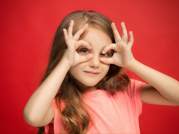 Free Photo happy teen girl standing, smiling isolated on trendy red studio background. beautiful funny portrait. young satisfy girl