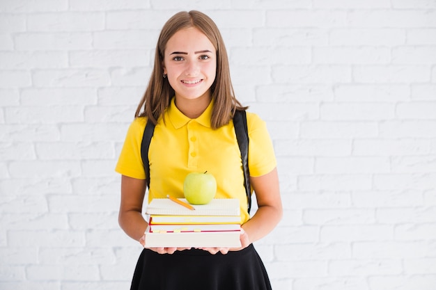 Happy teen girl with textbooks and apple