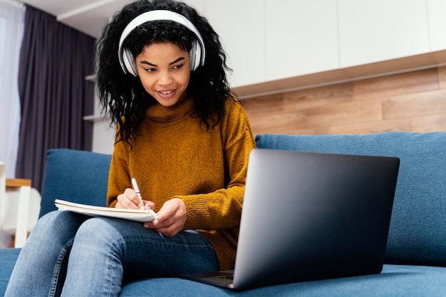 Happy teenage girl with headphones during online school