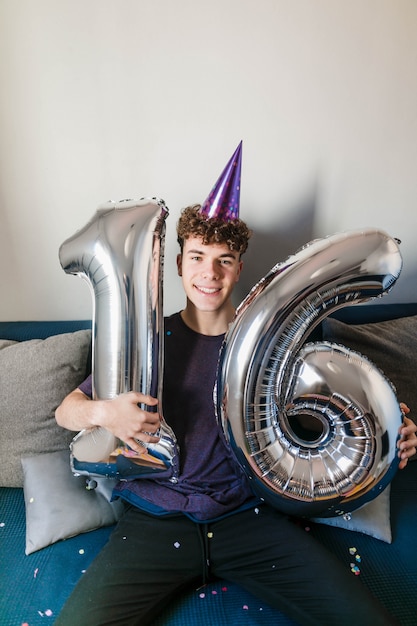 Free photo happy teenager holding birthday balloons