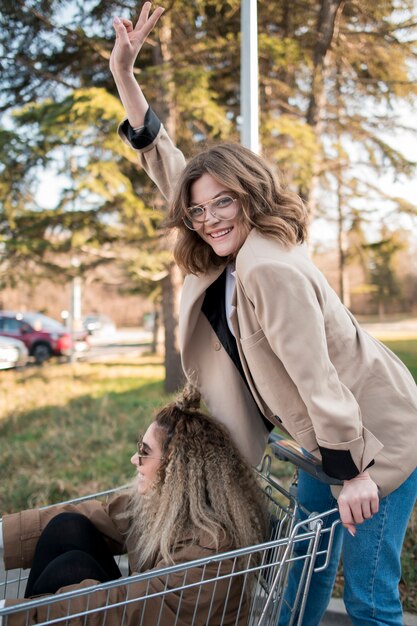 Happy teenagers posing with shopping cart