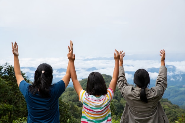 Happy teens deep breath fresh air on top mountain breathing clean air