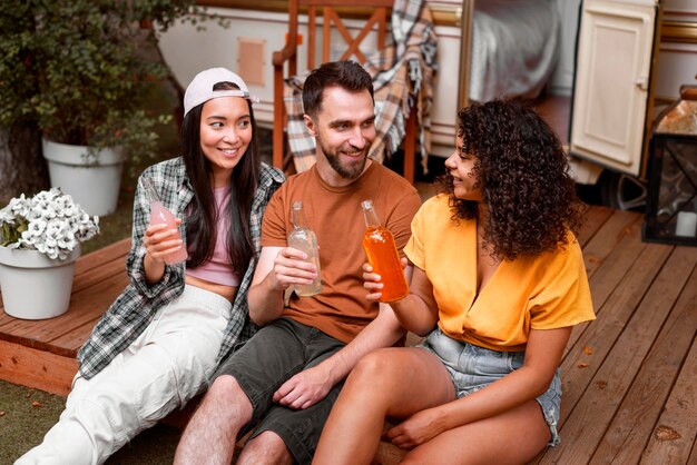 Happy three friends drinking outdoors