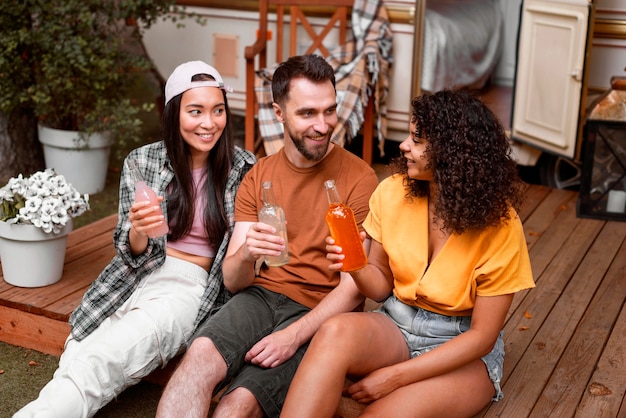 Happy three friends drinking outdoors