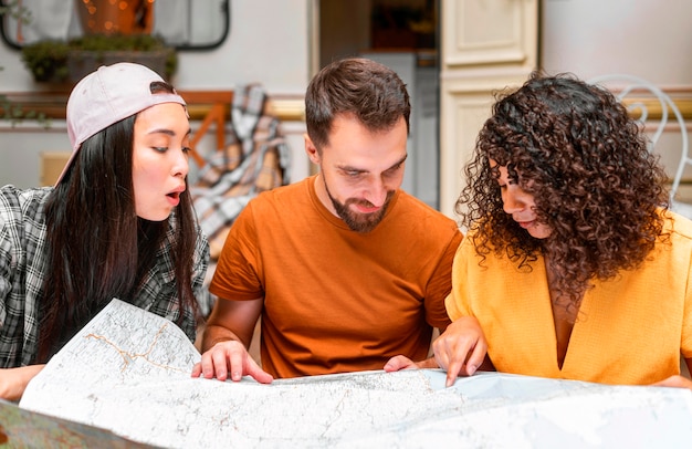 Happy three friends using a map