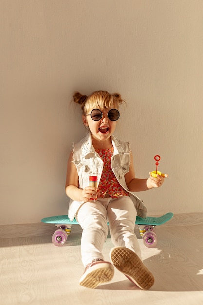 Free Photo happy toddler sitting on skateboard