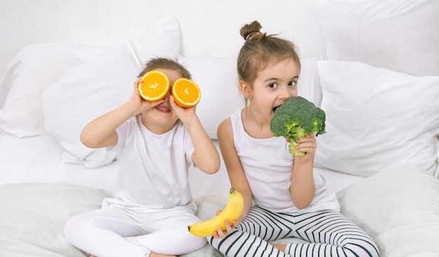 Free photo happy two cute children playing with fruits and vegetables .