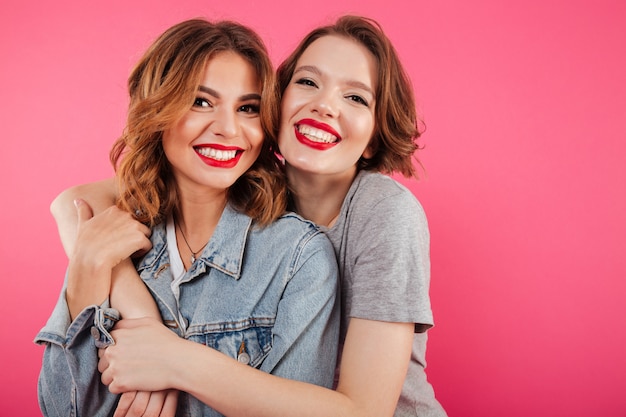 Happy two women friends hugging.