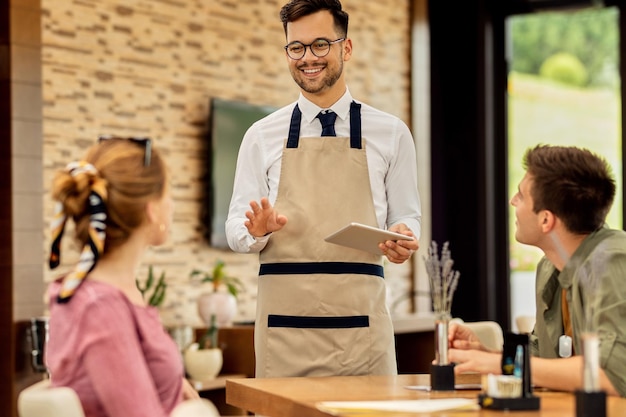 Free photo happy waiter taking order from guests in a cafe