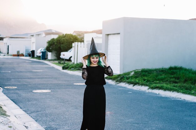 Happy witch holding her hat