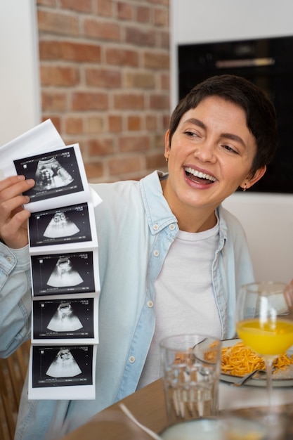 Happy woman announcing pregnancy with ultrasound