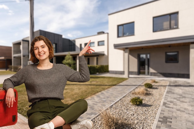 Free photo happy woman on the background of a new house. portrait of first time buyer, house owner, apartment renter, flat tenant or landlady. moving day and buying own property concept.