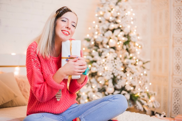 Happy woman on bed with gift box