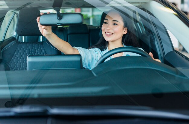 Happy woman in car dealership