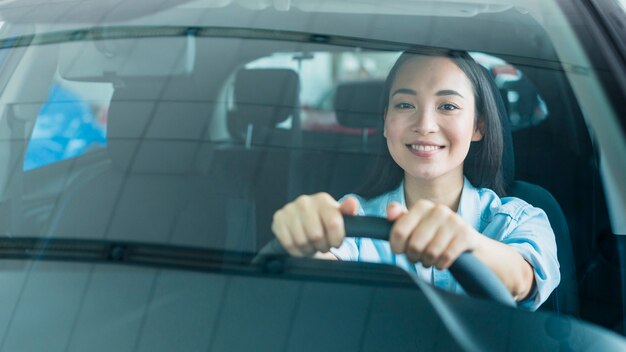 Happy woman in car dealership