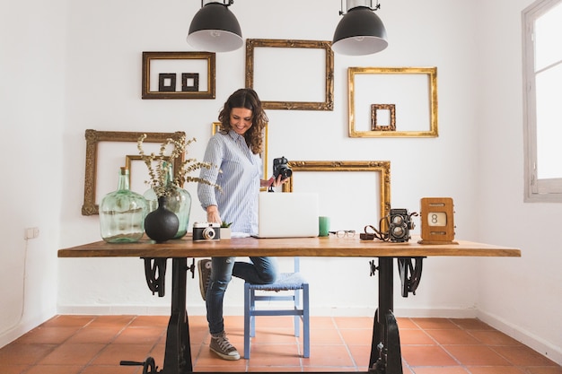 Free photo happy woman checking documents and holding a camera