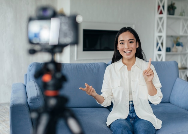 Happy woman doing a vlog indoors