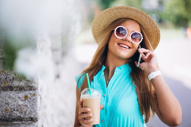 Happy woman drinking coffee and talking on the phone