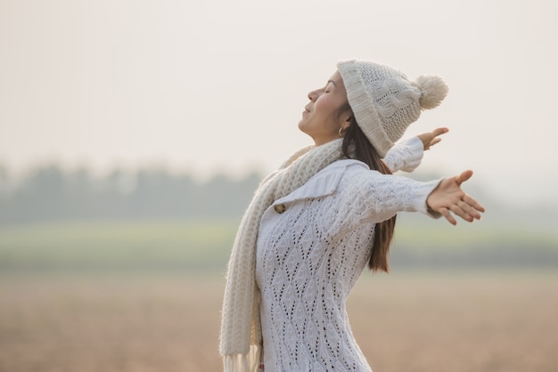 Happy woman enjoying in idyllic nature, celebrating freedom and rising her arms