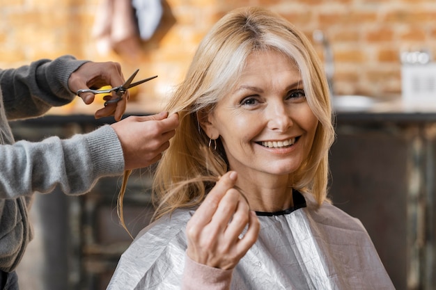 Free photo happy woman getting a haircut at home with hairdresser