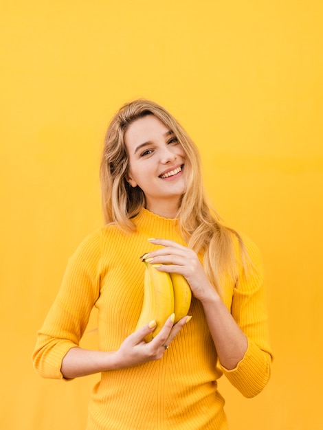 Happy woman holding bananas