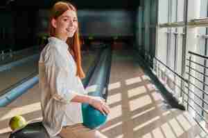 Free photo happy woman holding a bowling ball