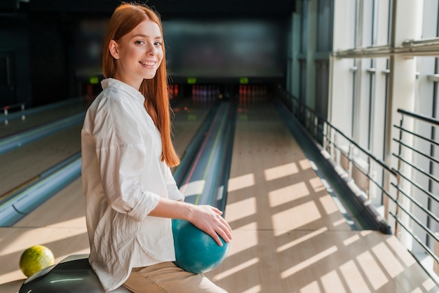 Happy woman holding a bowling ball