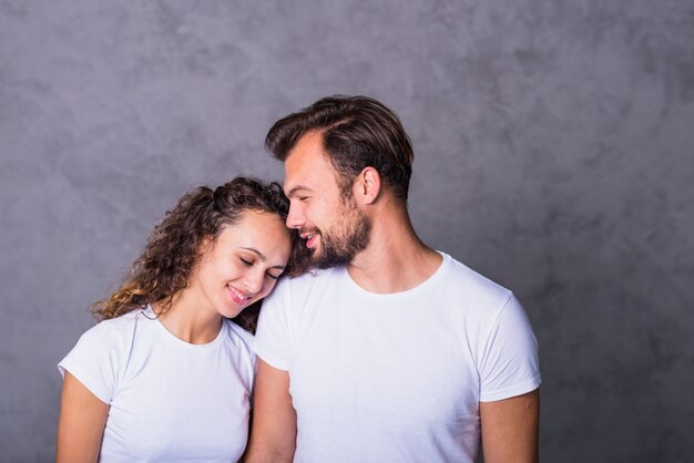 Happy woman holding head on man shoulder