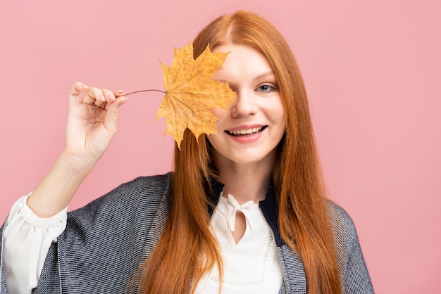 Happy woman holding yellow leaf