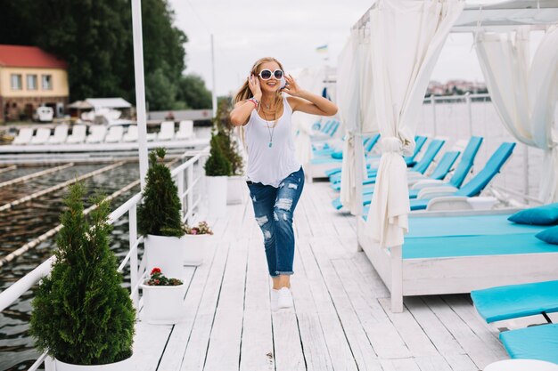 Free Photo happy woman hopping along pier