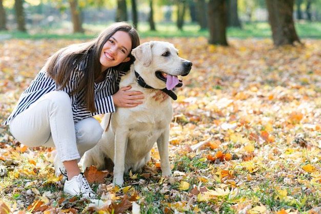 Happy woman hugging her dog in the park