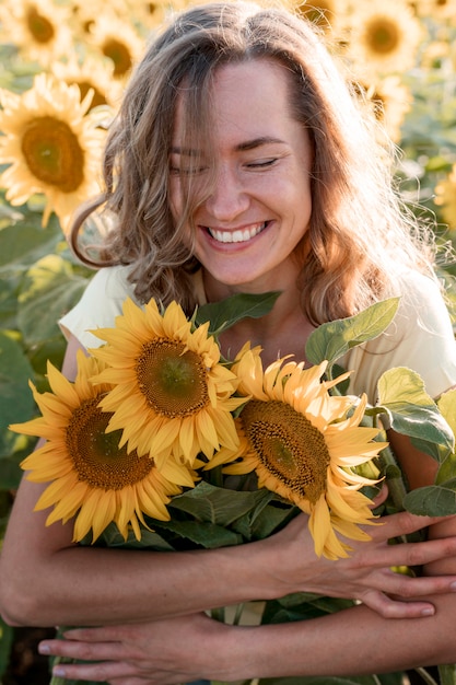 Happy woman hugging sunflowers