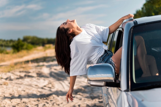 Free photo happy woman leaning on car window