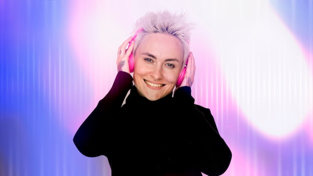 Free photo happy woman listening to music on her pink headphones