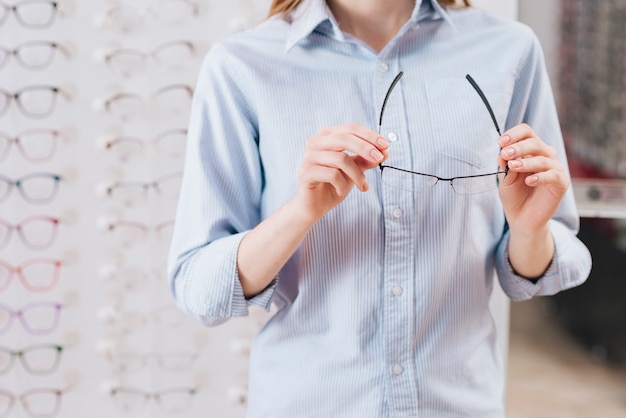 Free photo happy woman looking for new glasses at optometrist