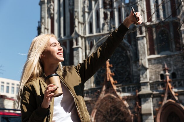 Happy woman making selfie on smartphone