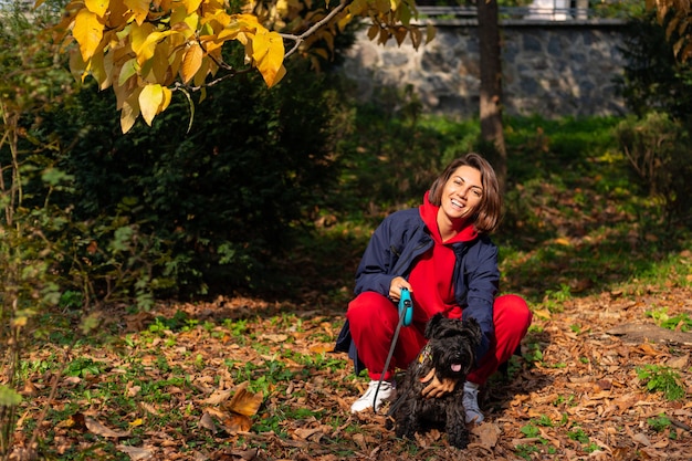 Happy woman in park with autumnal leaves