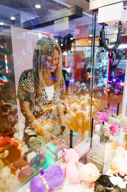 Happy woman playing arcade machine