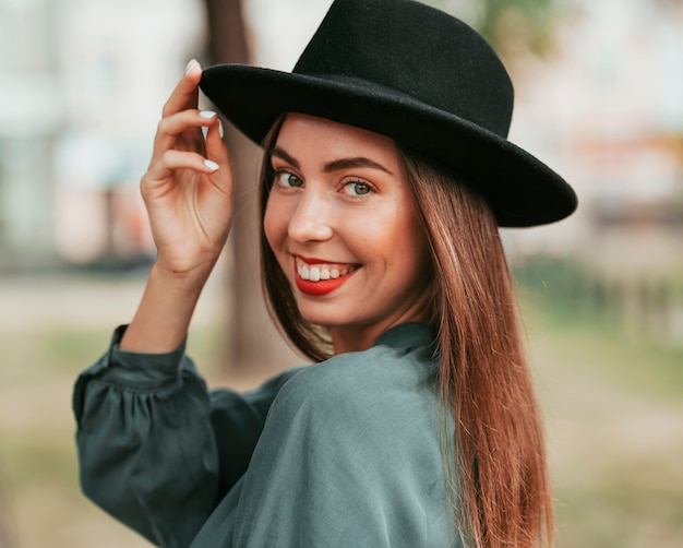 Free Photo happy woman posing with a black hat