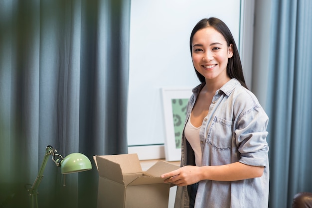 Happy woman posing with box she received after ordering online