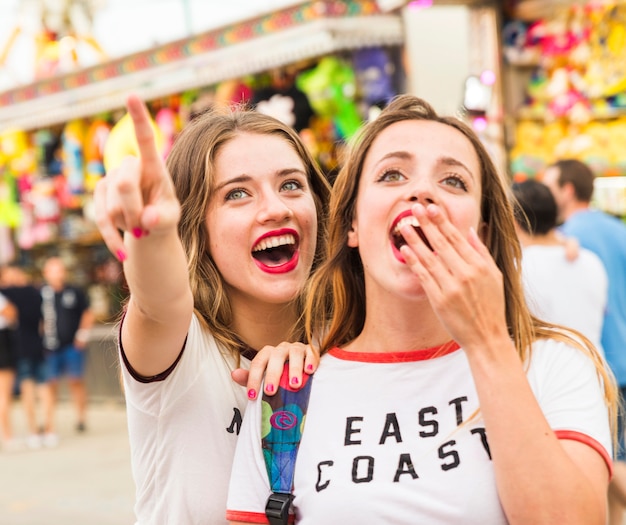 Free Photo happy woman showing something to her female friend