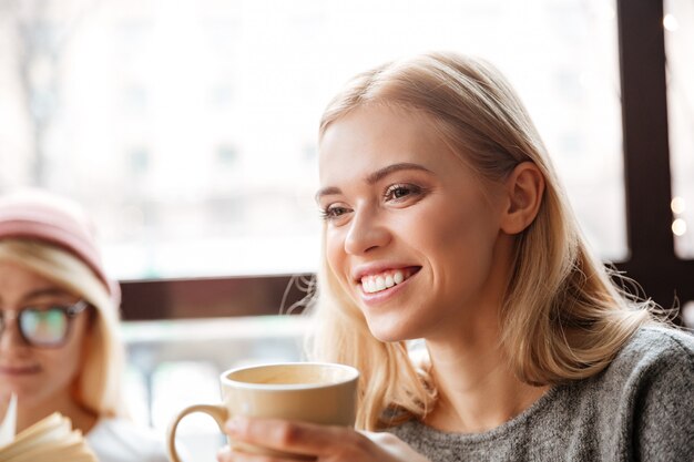 Free photo happy woman sitting in cafe and drinking coffee.