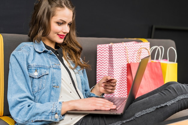 Free Photo happy woman sitting at home enjoying online shopping